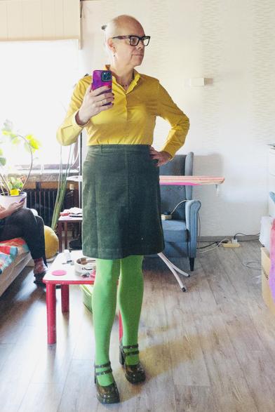 I'm wearing a yellow blouse, a moss green corduroy skirt that ends a hand over the knee, bright green tights and olive green patent leather Mary Janes with two ankle straps.