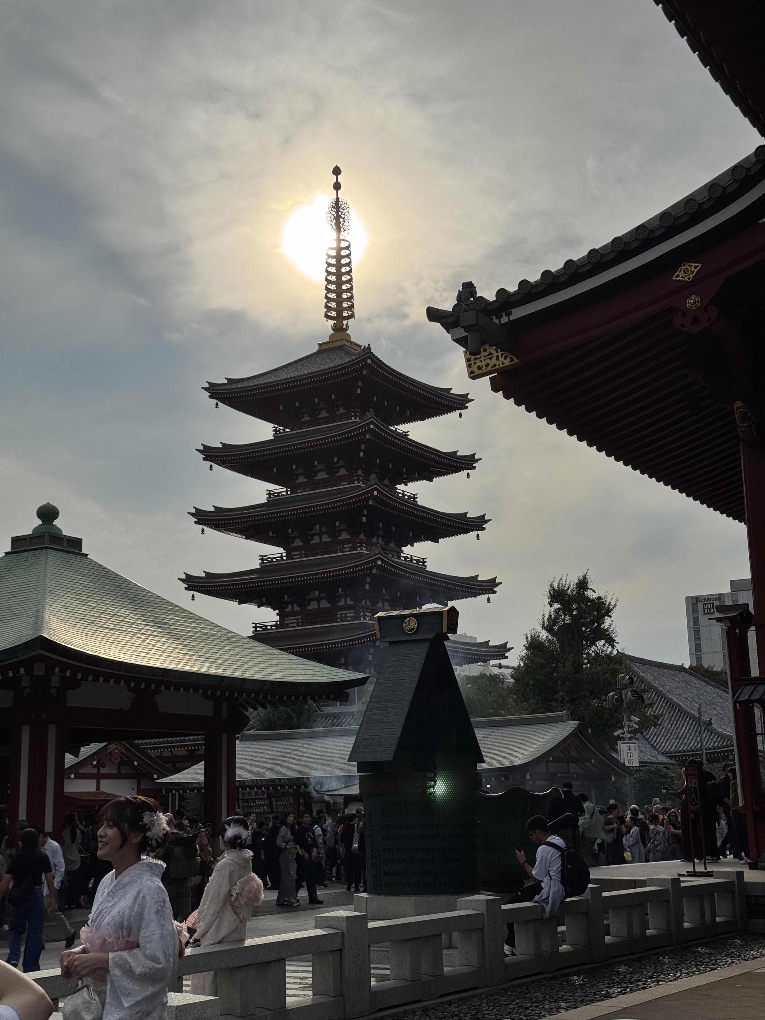 The pagoda at Senso-ji shrine with the lightly clouded sun directly behind the top bits.