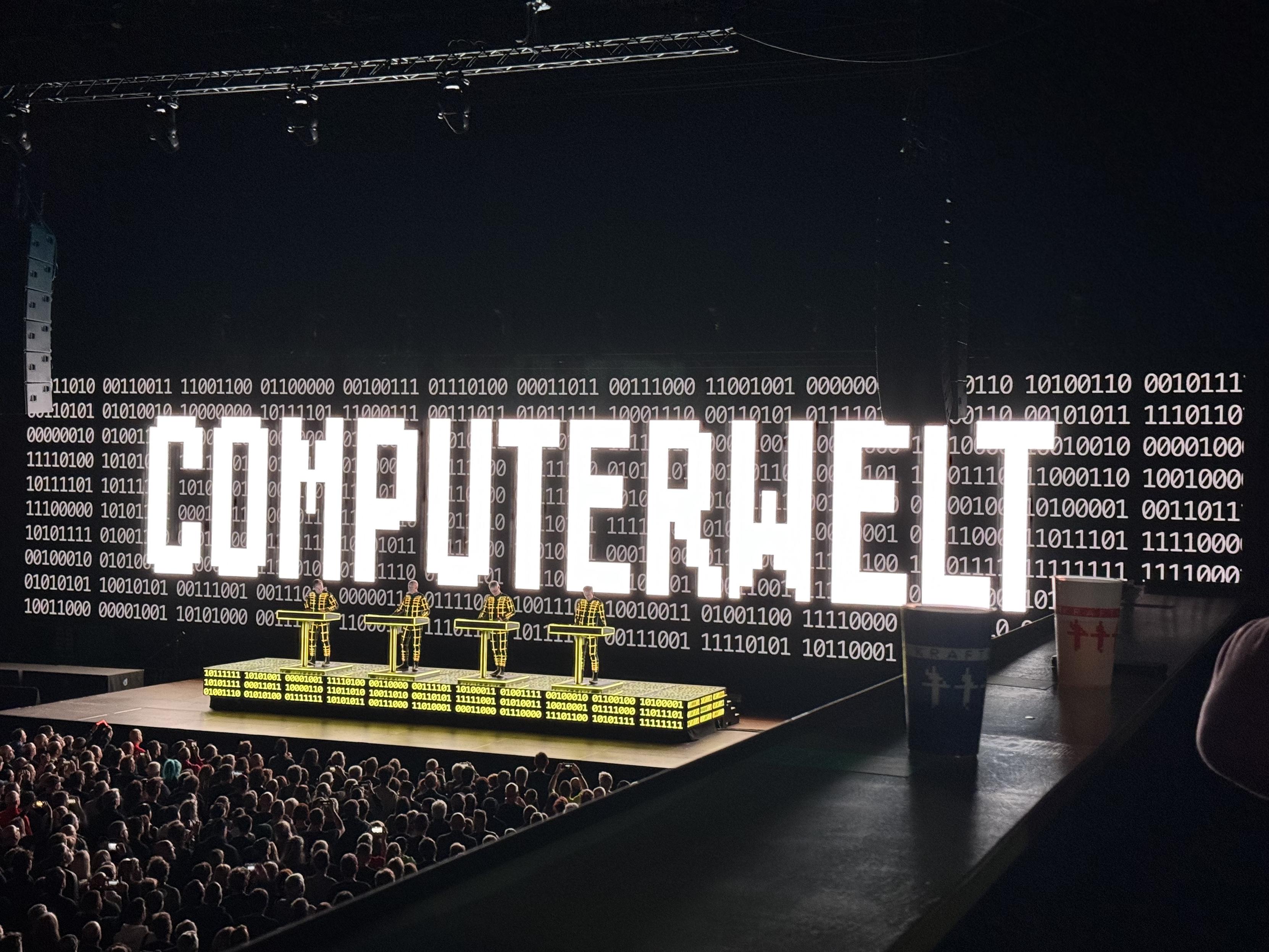 Same stage as before but the word Computerwelt I. Large white letters in front of yellow coloured artists
